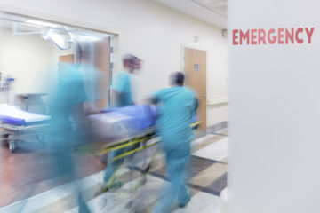Doctors Wheeling Patient quickly down hallway